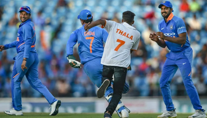 MS Dhoni running away from a fan.