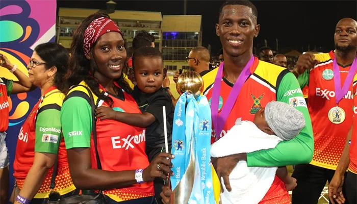 Shamar Joseph holding the CPL title with his family.